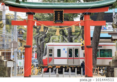 岡崎市、六所神社の鳥居の前を走る名鉄電車 101444511
