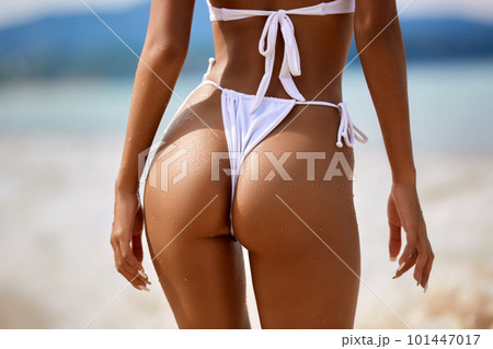 Sexy model's ass in white bikini on the blue water background Sexy model's ass in white bikini on the blue water background 101447017