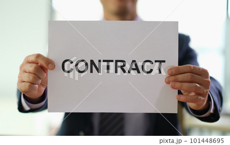Businessman holding paper document contract in hands in office closeup Businessman holding paper document contract in hands in office closeup 101448695