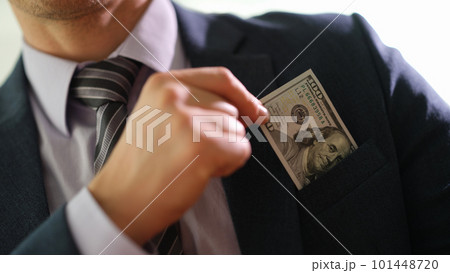 Businessman taking hundred dollar bill out of jacket pocket closeup 101448720