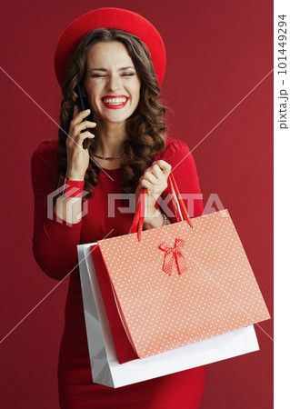 woman against background with shopping bags talking on phone 101449294