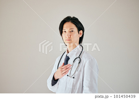 手を胸に当てて立つ白衣の若い男性 101450439