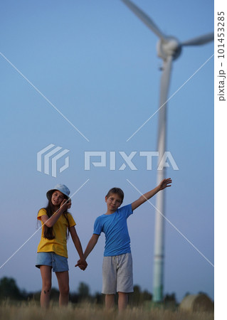 School boy stand on the wind farm. Wind turbines alternative electricity sources. Future of kid and sustainable resources. People in the community with wind generators turbines. Selective focus 101453285