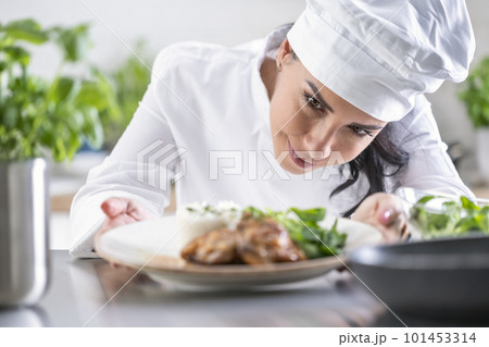 An experienced chef checks the finished food before the waiter takes it to the guest in the restaurant 101453314