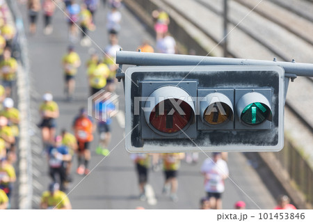Traffic light in the foreground - people running a half marathon on the bridge 101453846