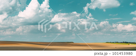Tractor Plowing Field In Spring Season Sunny Day. Bright Clouds On Background. Countryside Rural Field Landscape. Agricultural Concept 101453980