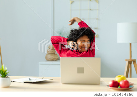 African american girl at home office relaxing stretching hands and body taking break from work on laptop. Joyful young woman freelancer businesswoman happy after work done satisfied by good result 101454266