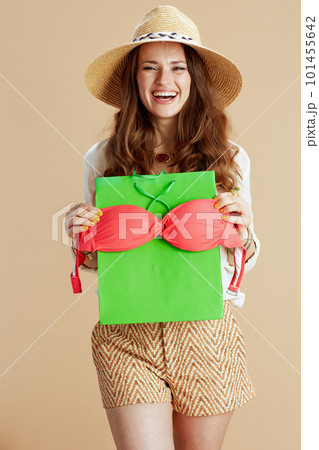 happy elegant female in blouse and shorts isolated on beige 101455642