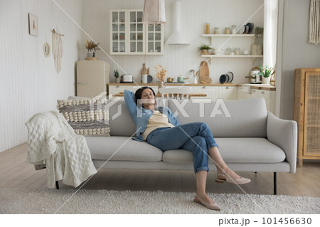 Calm sleepy middle aged woman resting on soft couch Calm sleepy middle aged woman resting on soft couch 101456630