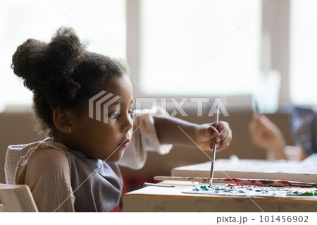 Serious artistic school African American pupil girl painting on canvas Serious artistic school African American pupil girl painting on canvas 101456902