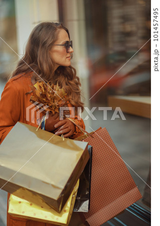 modern woman in orange trench coat with shopping bags modern woman in orange trench coat with shopping bags 101457495
