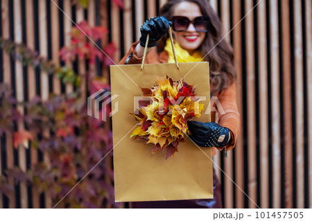 Closeup on happy elegant woman in orange trench coat Closeup on happy elegant woman in orange trench coat 101457505