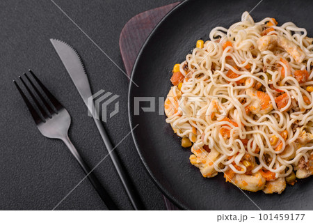 Delicious noodles with chicken and vegetables or udon on a black ceramic plate Delicious noodles with chicken and vegetables or udon on a black ceramic plate 101459177
