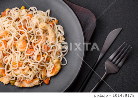 Delicious noodles with chicken and vegetables or udon on a black ceramic plate Delicious noodles with chicken and vegetables or udon on a black ceramic plate 101459178