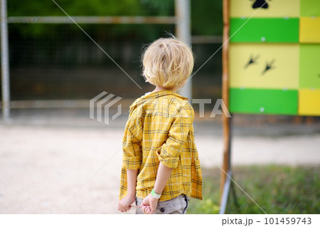Little boy is visiting outdoors petting zoo. Child having fun in farm with animals. Children and animals. Entertainment for family with kids on holidays Little boy is visiting outdoors petting zoo. Child having fun in farm with animals. Children and animals. Entertainment for family with kids on holidays 101459743