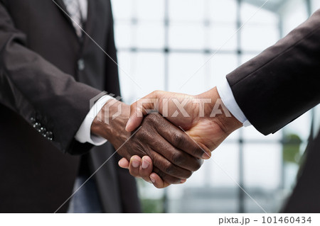 Businessmen reach out to each other to shake hands Businessmen reach out to each other to shake hands 101460434