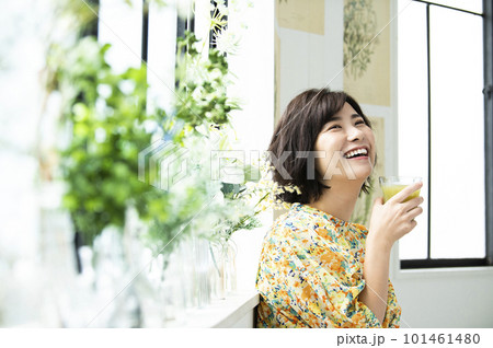 笑顔でグリーンスムージーを飲む若い女性 笑顔でグリーンスムージーを飲む若い女性 101461480