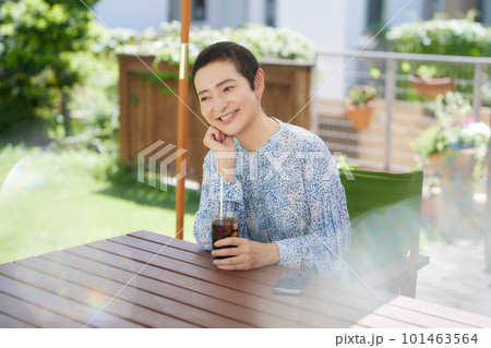 オープンカフェでアイスコーヒーを飲むミドル女性 101463564