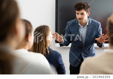 Young male teacher giving lecture to group of student 101468169