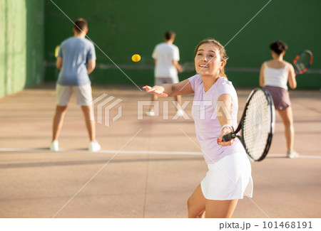 Woman playing frontenis with partners at sunny day, healthy lifestyle concept 101468191