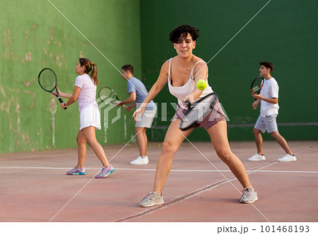 Woman playing frontenis with partners at sunny day, healthy lifestyle concept 101468193