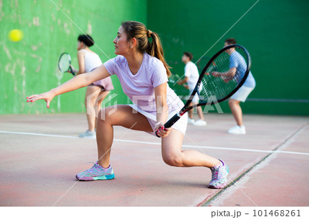 Expressive resolved fit girl playing frontenis ball friendly match on court Expressive resolved fit girl playing frontenis ball friendly match on court 101468261