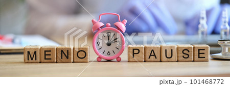 Word menopause collected of wooden cubes in raw and pink alarm-clock 101468772