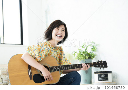 笑顔でギターを弾く若い女性 笑顔でギターを弾く若い女性 101468780