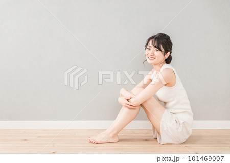 フローリングに座る笑顔の美しいアジア人女性（美容・ダイエット・脱毛） 101469007