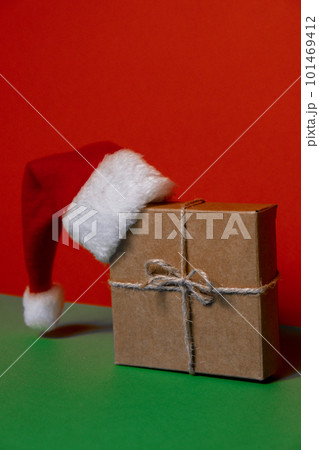 Santa hat on paper gift box present on green background. Copy space for your text. Mock up for advertisement. Holiday Christmas composition 101469412