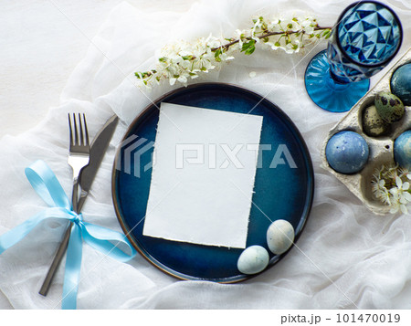 Festive Easter table setting with eggs and flowers on white background Festive Easter table setting with eggs and flowers on white background 101470019