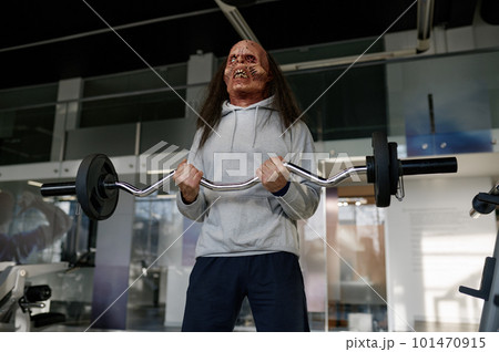 Zombie man in sportswear training with barbell at modern gym 101470915
