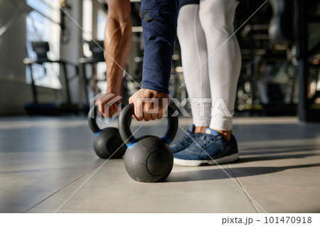 Cropped closeup shot of sportsman hands taking kettlebell from floor 101470918