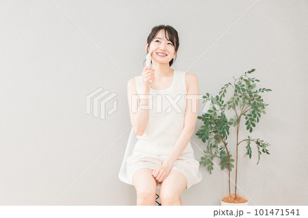 美顔器を使ってホームエステ・リフトアップ・マッサージする笑顔のアジア人女性 101471541