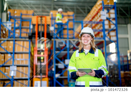 Portrait of pretty young warehouse worker woman hold tablet and look at camera with smiling 101472326
