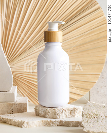 White One pump bottle on biege stones against dried palm leaf. Cosmetic Mockup White One pump bottle on biege stones against dried palm leaf. Cosmetic Mockup 101474730