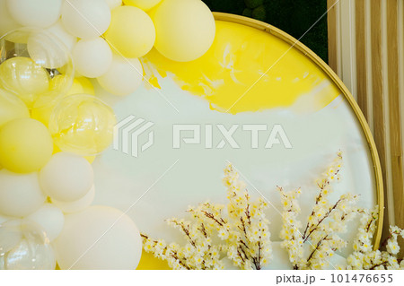 white-yellow photo zone with balloons and branches of spring flowering trees. white-yellow photo zone with balloons and branches of spring flowering trees. 101476655