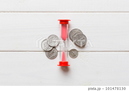 Deadline and time is money concept with hourglass and US coins currency. sand clock time for saving concept Deadline and time is money concept with hourglass and US coins currency. sand clock time for saving concept 101478130
