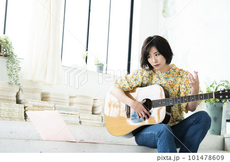 ギターを弾く若い女性 101478609