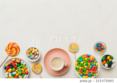 Coffee cup with chocolates and colored candy. Top view on table background with copy space Coffee cup with chocolates and colored candy. Top view on table background with copy space 101478965