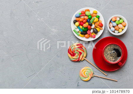 Coffee cup with chocolates and colored candy. Top view on table background with copy space 101478970