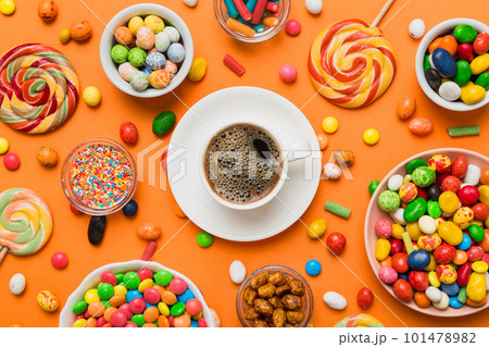 Coffee cup with chocolates and colored candy. Top view on table background with copy space 101478982