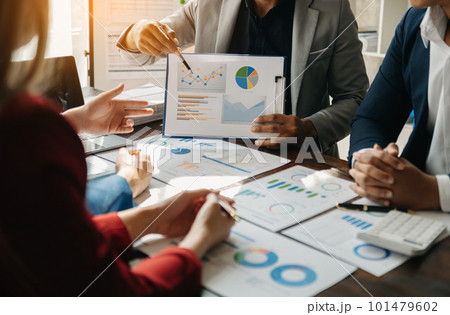 Business documents on office table with smart phone and calculator digital tablet and graph business with social network diagram and two colleagues discussing data working in the office. 101479602