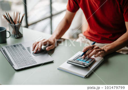Women counting coins on calculator taking from the piggy bank. hand holding pen working on calculator to calculate on desk about cost at home office.. Women counting coins on calculator taking from the piggy bank. hand holding pen working on calculator to calculate on desk about cost at home office.. 101479799