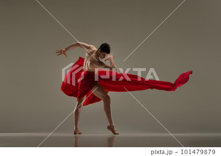 Toreador. Artistic performance with young handsome man dancing with red fabric against grey studio background Toreador. Artistic performance with young handsome man dancing with red fabric against grey studio background 101479879