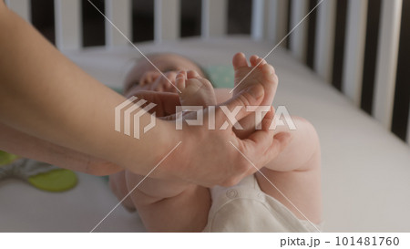 Mother touching or doing massage adorable newborn legs 101481760