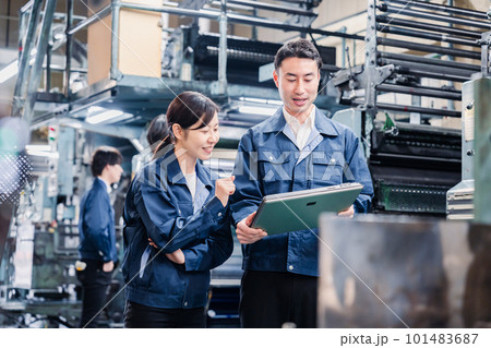 タブレットを見ながら工場で議論をするスタッフ タブレットを見ながら工場で議論をするスタッフ 101483687