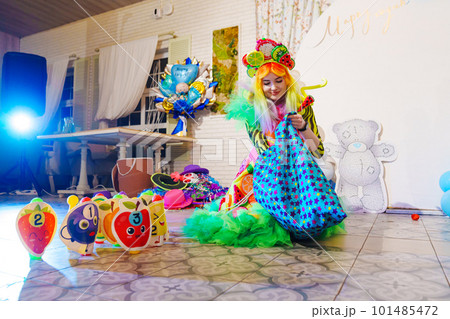 a woman in a stage costume works as an animator at a children's party.  101485472