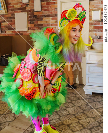 a woman in a stage costume works as an animator at a children's party.  101485473