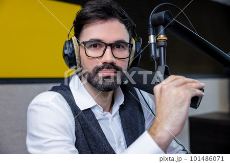Dark-haired young man in headphones looking serious 101486071